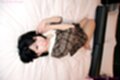 Lying on bed knees raised in dress