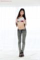 Raising tee shirt wearing jeans in high heels.jpeg