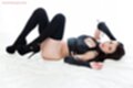 Lying on her back knees drawn up black stockings in high heels