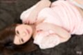 Lying on her back pushing her breasts together in dress