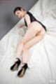Lying on her side dress raised over her ass wearing black high heels