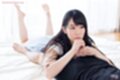 Kasugano yui lying on her front bare feet raised long hair giving handjob