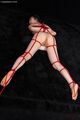 Lying on her front bound with shibari rope legs open bald pussy bare feet