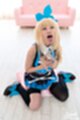 Kneeling on floor holding glass to her chest tongue out