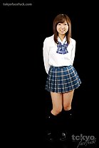 Student in uniform hands clasped behind her back wearing pleated skirt